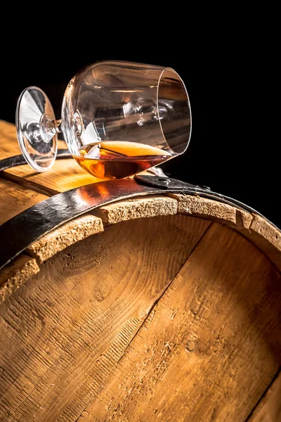 Cognac in glass on old vintage barrel — Stock Photo, Image