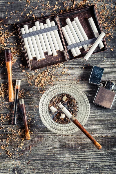 Сигареты, пепельница и курительная трубка — стоковое фото