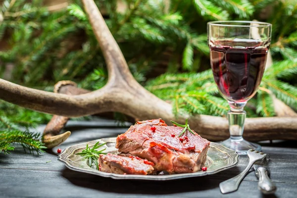 Vinho tinto em um copo e veado em uma chapa — Fotografia de Stock