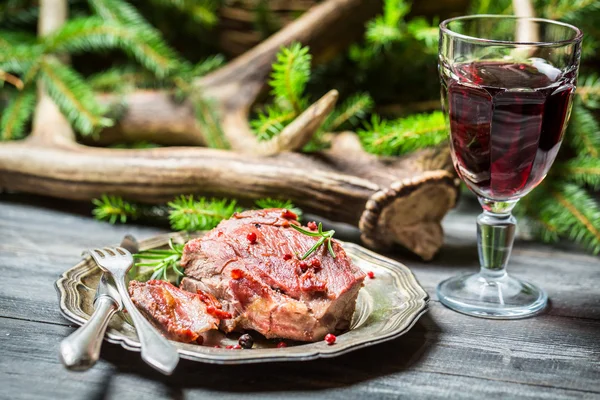 Färskt älgkött på en tallrik och rött vin — Stockfoto