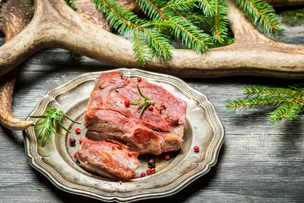 鹿肉、鹿の角の周りプレート上 — ストック写真