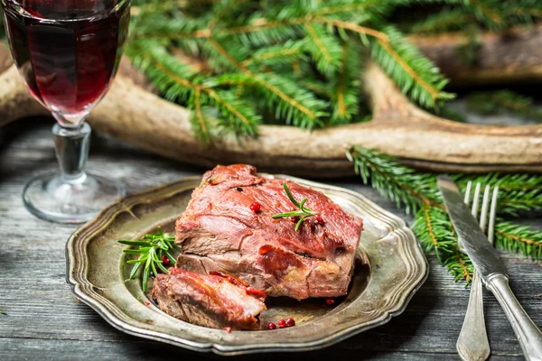 Verse hertenvlees met rode wijn op de achtergrond van geweien en spr — Stockfoto