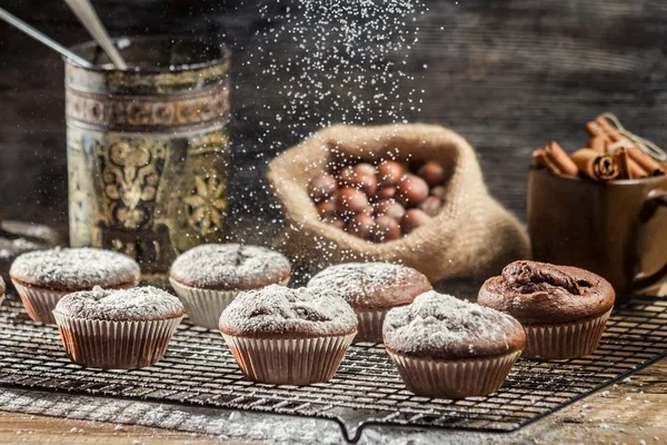 Klesající moučkový cukr na čerstvé čokoládové muffiny — Stock fotografie