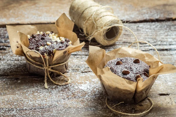 Decorating chocolate muffins with paper and string — Stock Photo, Image