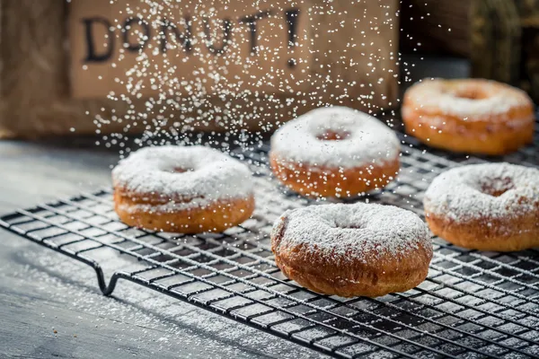 Vallende poeder suiker op donuts — Stockfoto