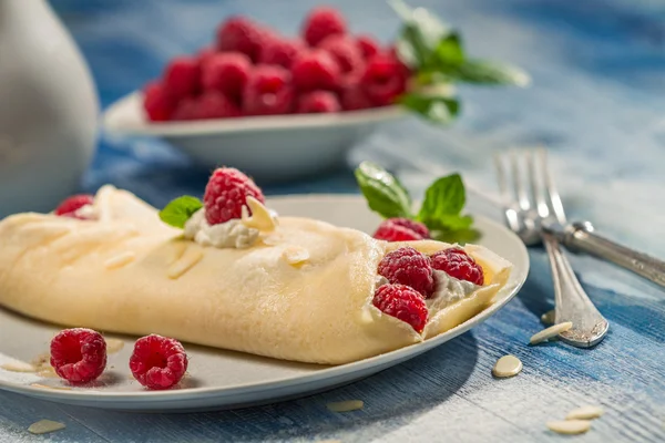 Primer plano de panqueques de frambuesa servidos con crema batida — Foto de Stock