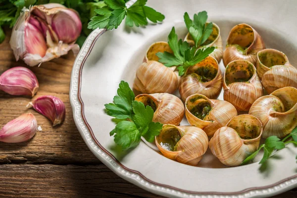 Snails baked in garlic butter and served with parsley — Stock Photo, Image