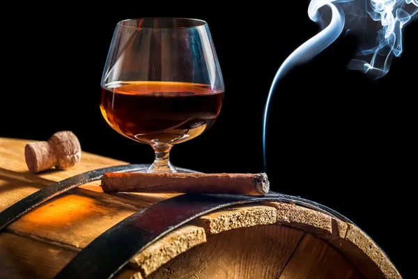 Aroma van Cubaanse sigaren en cognac op zwarte achtergrond — Stockfoto