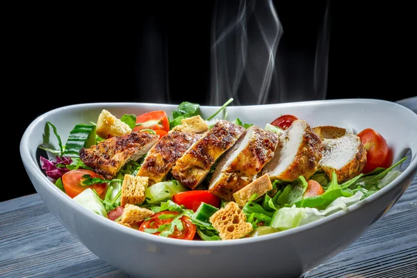 Hot chicken and fresh vegetables in healthy salad