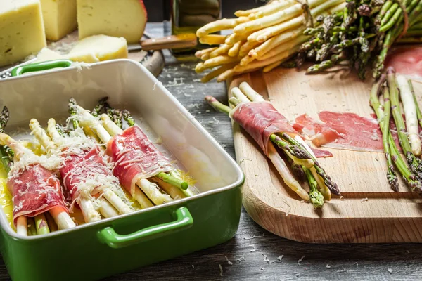 Preparation asparagus with prosciutto ham and cheese — Stock Photo, Image