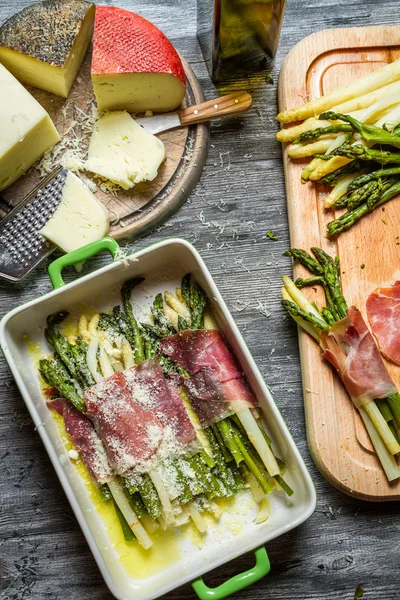 Asparagus wrapped in Parma ham with cheese — Stock Photo, Image