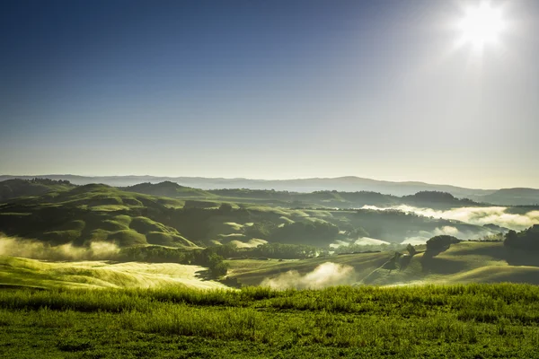 Neblige Hügel in der Toskana bei Sonnenaufgang — Stockfoto