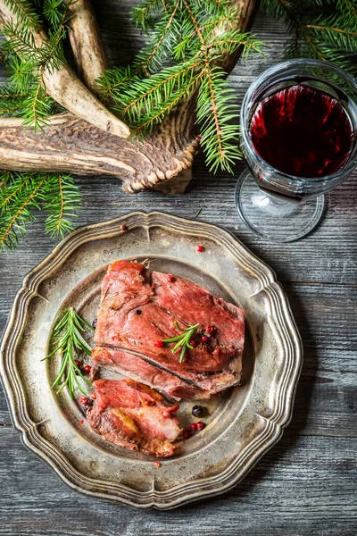 Pièce de venaison servie avec du vin rouge — Photo