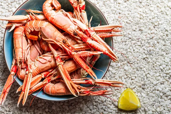 Scampi served with lemon on the beach — Stock Photo, Image