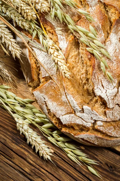 Wholemeal bread on old wooden table — Stock Photo, Image