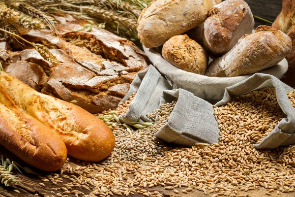 Vari tipi di pane integrale su vecchio tavolo di legno — Foto Stock