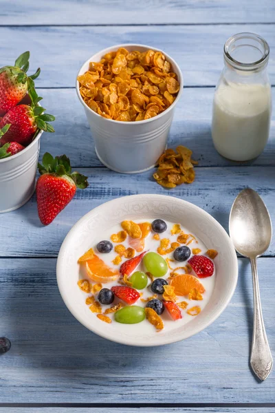 Corn flakes with fruit and milk — Stock Photo, Image