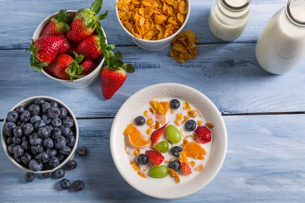 Preparations for breakfast corn flakes and fruits — Stock Photo, Image