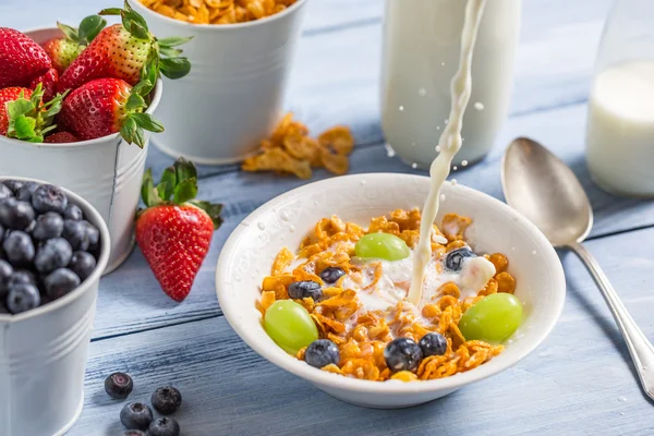 Flocos de milho com frutas inundadas com leite — Fotografia de Stock