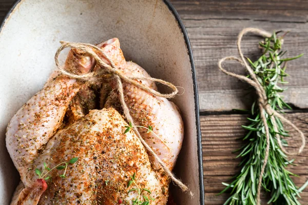 Primo piano di pollo crudo con erbe in casseruola — Foto Stock