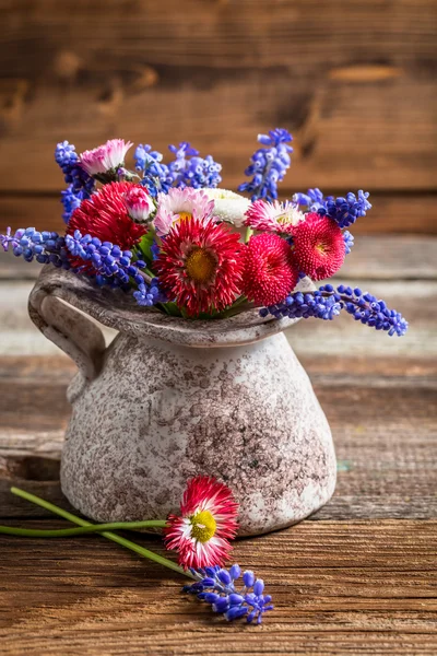 Lentebloemen in een vaas op houten tafel — Stockfoto