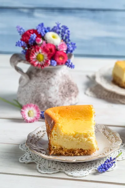 Cheesecake and spring flowers — Stock Photo, Image