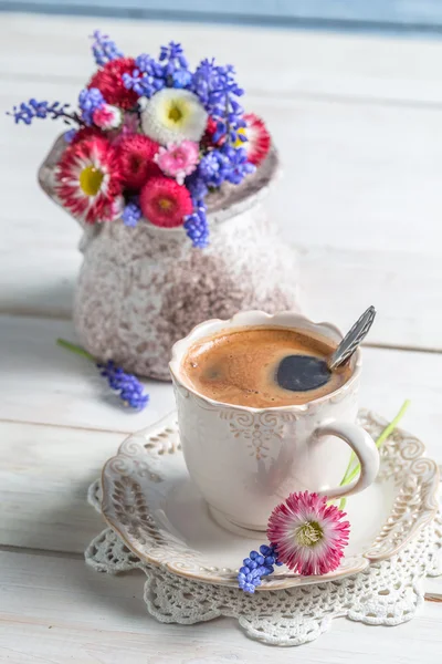 Šálek kávy a jarní květiny — Stock fotografie