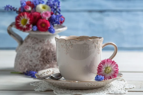 Close-up van madeliefjebloemen en kopje koffie — Stockfoto
