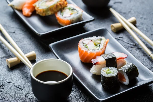 Närbild av sushi på en svart keramisk — Stockfoto