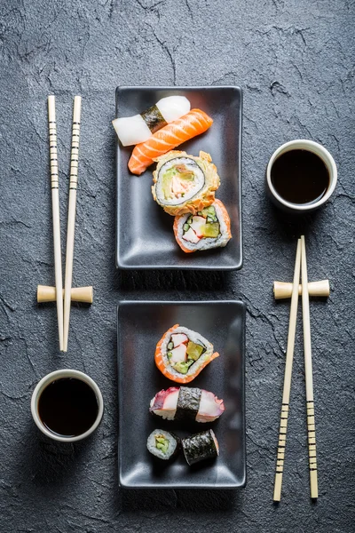 Sushi für zwei Personen auf schwarzem Stein serviert — Stockfoto