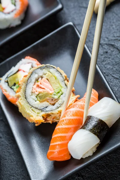 Sushi äts med pinnar — Stockfoto