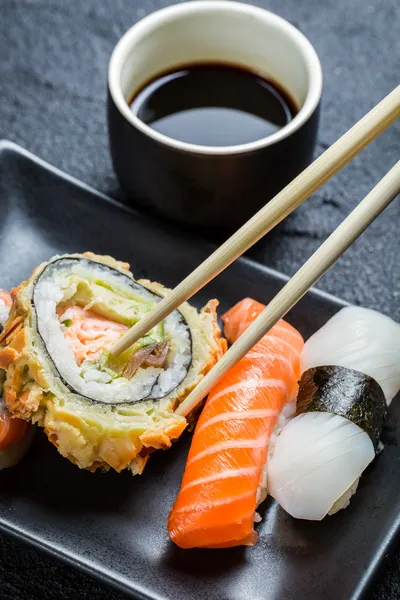 Sushi in der dunklen Keramik serviert — Stockfoto