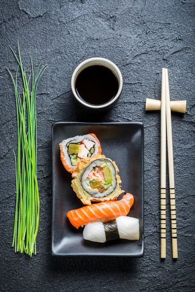 Sushi fresco, ceramica scura e bacchetta — Foto Stock