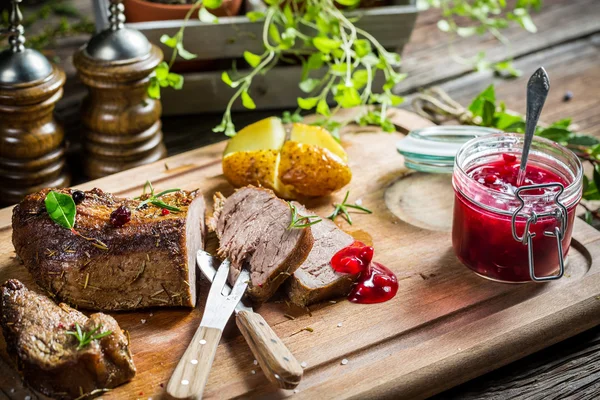 Primo piano di carne di cervo con salsa di mirtilli rossi e verdure — Foto Stock