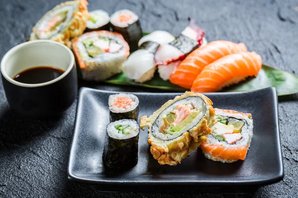 Frisches Sushi auf der schwarzen Keramikschale — Stockfoto