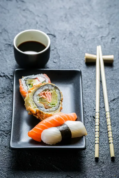 Sushi auf schwarzer Keramik serviert — Stockfoto