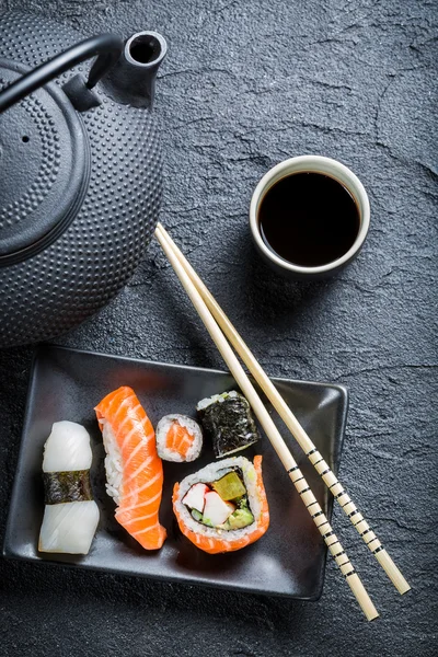 Fresh sushi served in a black ceramic — Stock Photo, Image