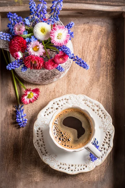 Káva a jarní květiny na starý dřevěný tác — Stock fotografie