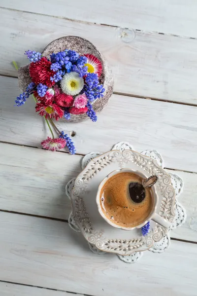 Květy sedmikrásky a šálek kávy — Stock fotografie