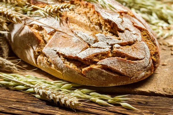 Wholemeal bread on old wooden table — Stock Photo, Image