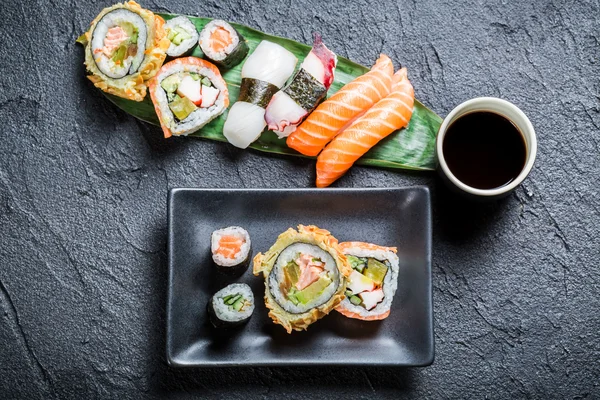 Sushi com molho de soja na rocha preta — Fotografia de Stock