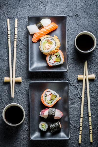 Sushi for to serveret på sort sten - Stock-foto