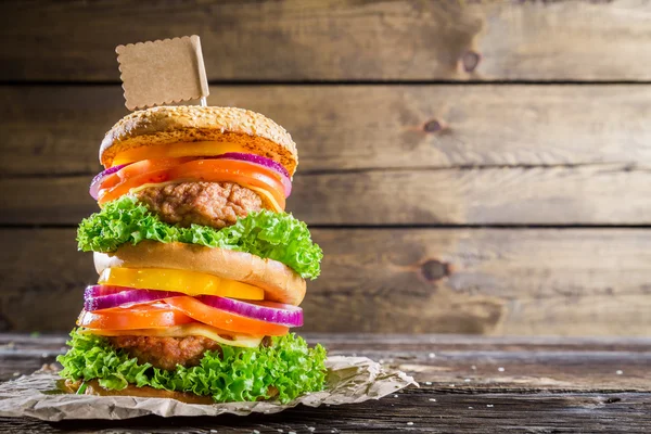 Piętrowy burger na drewniane tła z miejsca do menu — Zdjęcie stockowe