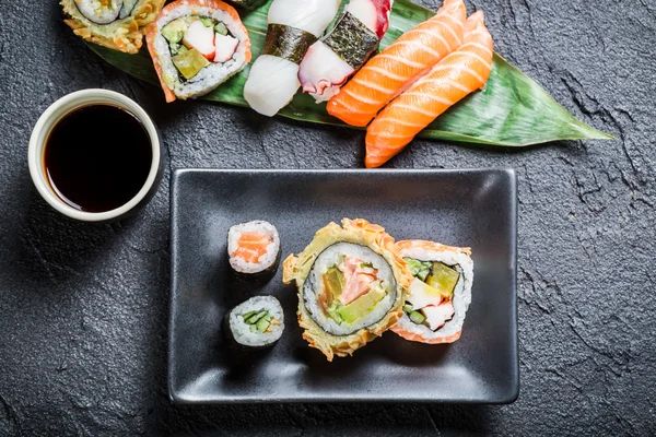 Sushi com molho de soja na rocha preta — Fotografia de Stock