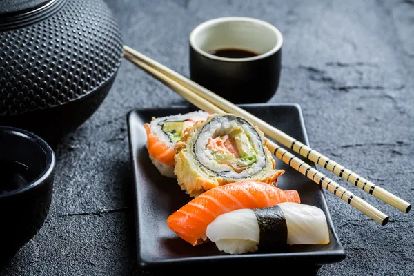 Closeup of fresh sushi served in with tea — Stock Photo, Image