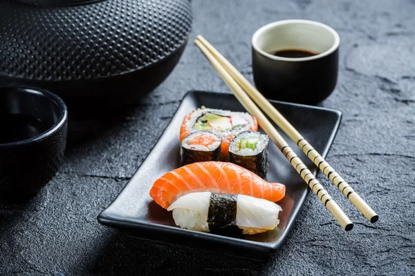 Närbild av färsk sushi serveras i en svart keramik — Stockfoto