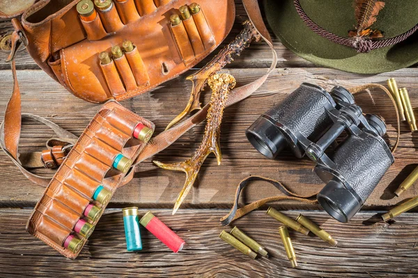 Bag with bullets, binoculars and hat in a hunting lodge — Stock Photo, Image