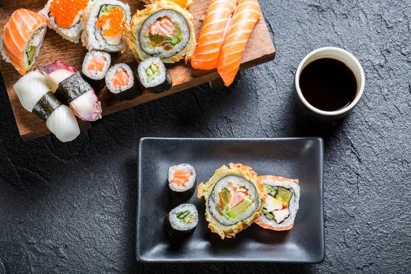 Sushi geserveerd met sojasaus op zwarte steen — Stockfoto