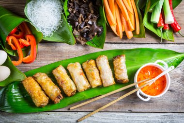 Fried spring rolls surrounded by ingredients clipart