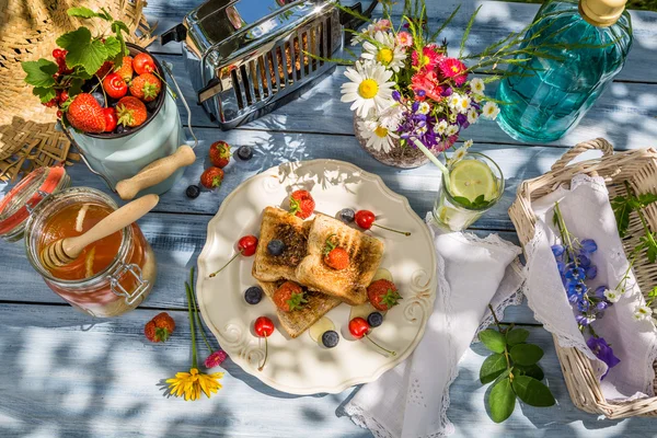 Summer breakfast in the garden with fruit toast with honey — Stock Photo, Image